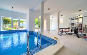 a swimming pool in a house with a gym at Apartments ROYAL in Kornić