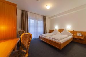 a hotel room with a bed and a window at Hotel & Landgasthaus Pfeifertal in Eulenbis