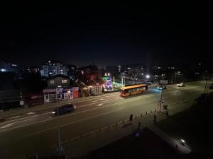 a bus driving down a city street at night at Uni Time Apartment by LMG in Sofia