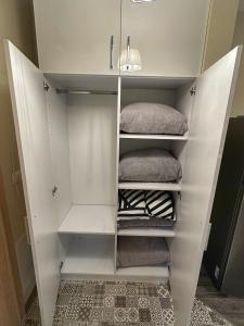 a white closet with white shelves and towels at Uni Time Apartment by LMG in Sofia