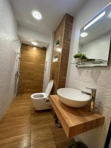 uma casa de banho com um lavatório branco e um WC. em Uni Time Apartment by LMG em Sófia