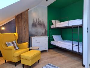 a green room with a bunk bed and a chair at Nad Lipami in Szczyrk