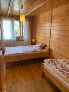 sypialnia z 2 łóżkami w drewnianym domku w obiekcie DOM na GÓRCE w mieście Stasikówka