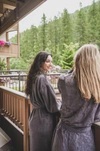 zwei Frauen stehen auf einem Balkon und sehen sich an in der Unterkunft Hotel Pfeldererhof Alpine Lifestyle in Moos in Passeier