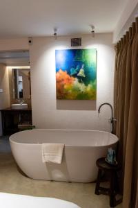 uma banheira na casa de banho com um quadro na parede em The Nanee em Bhaktapur