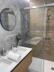 a bathroom with a sink and a shower with a mirror at Casa dos Alén in Ourense