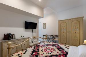 a bedroom with a bed and a tv on the wall at Bed & Breakfast Il Carignano in Cagliari