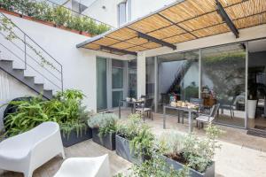 an outdoor patio with plants and a wooden pergola at Bed & Breakfast Il Carignano in Cagliari