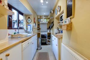 - une cuisine avec des placards blancs et un évier dans l'établissement Charming Historical Cottage in Scarborough, à Scarborough