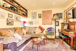 een woonkamer met een bank en een piano bij Family Country Cottage with a private Valley View in Scarborough