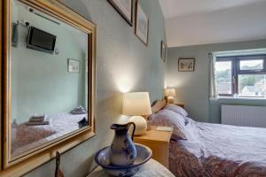 - une chambre avec un miroir, un lit et un vase sur une table dans l'établissement Charming Historical Cottage in Scarborough, à Scarborough