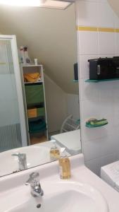 ein Badezimmer mit einem weißen Waschbecken und einem Spiegel in der Unterkunft exceptionnel penthouse vue mer in Wimereux