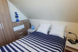 ein kleines Schlafzimmer mit einem blau-weißen gestreiften Bett in der Unterkunft exceptionnel penthouse vue mer in Wimereux