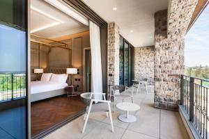 ein Schlafzimmer mit einem Bett und Stühlen auf einem Balkon in der Unterkunft Palazzo di Varignana in Varignana
