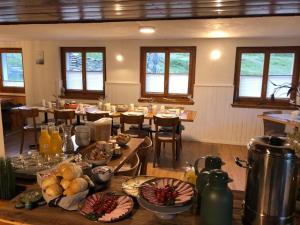 Täschalp Restaurant&Lodge في تاش: غرفة بها طاولات وكراسي عليها طعام