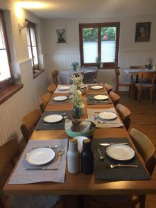 uma sala de jantar com uma longa mesa de madeira com configuração de lugar em Täschalp Restaurant&Lodge em Täsch