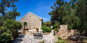 a stone house with a patio and a fence at Country house in Longós