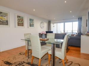 una sala da pranzo e un soggiorno con tavolo e sedie di 47 Bredon Court a Newquay