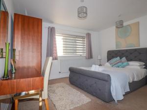 una camera con letto, scrivania, tavolo e sedia di 47 Bredon Court a Newquay