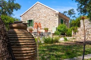 a stone house with a large vase in front of it at Country house in Longós