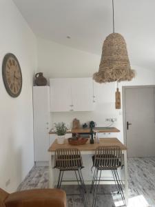 a kitchen with a table and two chairs and a clock at Fig&Olive Luxury one bedroom boutique in Pachna in Limassol