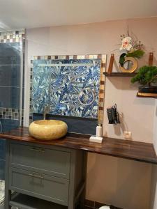 a bathroom counter with a sink and a tile wall at Chambre D'hôte Villa Maurice in Étretat