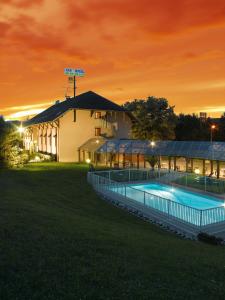 a building with two swimming pools at night at Logis Albhotel Grill in Alby