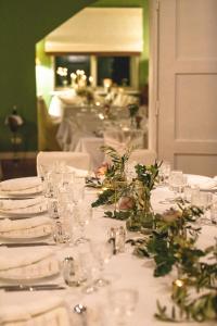 阿特湖的住宿－Villa Weiss，一张带眼镜和鲜花的白色桌子