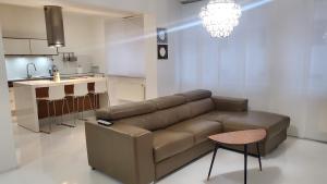 een woonkamer met een bruine bank en een keuken bij Apartmán Julie in Loket