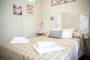 1 dormitorio con 1 cama con toallas en Aptos Centro A y B FAMORCAS, en Almodóvar del Río