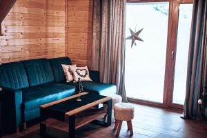 ein Wohnzimmer mit einem grünen Sofa und einem Tisch in der Unterkunft Dychnij Se in Szczyrk