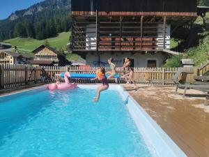 a group of girls jumping into a swimming pool at Residence Rumanon in Ortisei