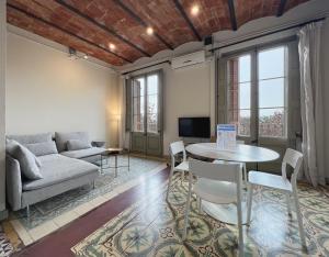 ein Wohnzimmer mit einem Sofa, einem Tisch und Stühlen in der Unterkunft Stay U-nique Apartments Borbó II in Barcelona