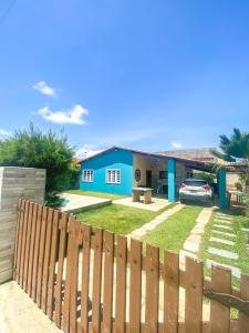 a blue house with a fence in front of a yard at Casa Rústica em Morro Branco - na quadra da praia in #N/A