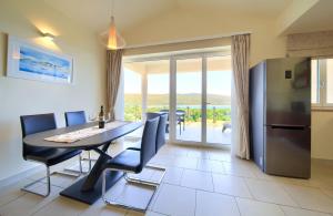 a kitchen and dining room with a table and a refrigerator at Apartments ROYAL in Kornić