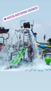 einen Wasserpark mit einer Wasserrutsche im Wasser in der Unterkunft Ndalem Kraton Hotel in Sidoarjo