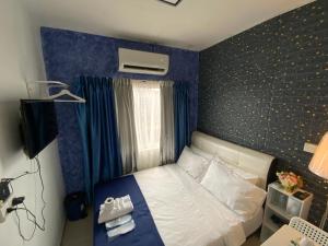 a bedroom with a bed with a blue wall at SBS HOTEL in Padang Besar