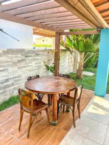a wooden table and chairs on a patio at Casa Rústica em Morro Branco - na quadra da praia in #N/A