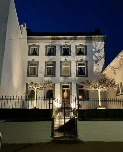 un bâtiment blanc avec une clôture devant lui dans l'établissement Huis van Loon, à Looz