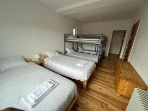 two beds in a room with wooden floors at Residencial Avenida Hostel in Tomar