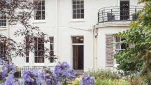 a white house with purple flowers in front of it at Pantybeiliau House Bed & Breakfast in Gilwern