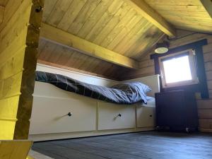 a bed in a room with a window at Landelijk gelegen houten huisje in Opperdoes