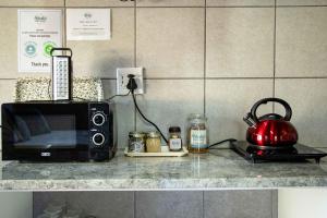 - un comptoir de cuisine avec un four micro-ondes et une bouilloire dans l'établissement Melsetter's Guesthouse, à Bloemfontein