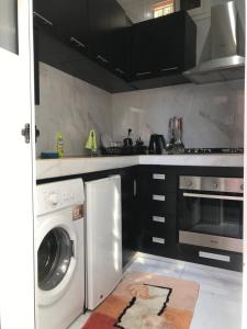 a kitchen with a washer and dryer in it at Studio Confort Fann Hock in Dakar