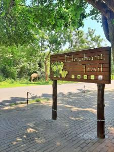 ein Zeichen für einen Zoo mit einem Elefanten im Hintergrund in der Unterkunft Elephant Trail in Udawalawe