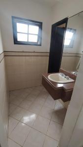 y baño con lavabo y espejo. en Apartamento encantador a beira mar, en Guarapari