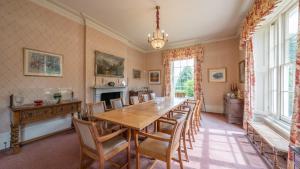 a dining room with a wooden table and chairs at Pantybeiliau House Bed & Breakfast in Gilwern