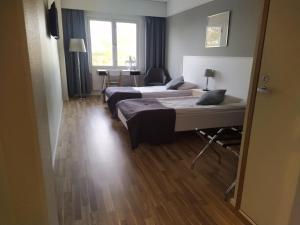 een hotelkamer met 2 bedden en een tafel bij Hotel Kalkstrand in Pargas