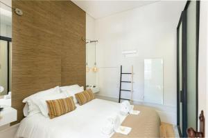 a bedroom with a large white bed with towels on it at Soprano Loft Porto Center - by Guest SPA in Porto