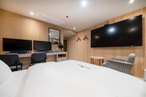 a hotel room with a bed and a flat screen tv at Gorilla Hotel in Wonju